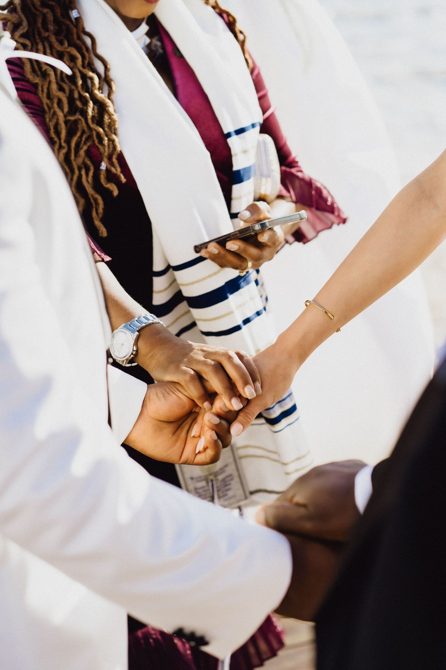Close-up of hands during a traditional wedding ceremony ritual.