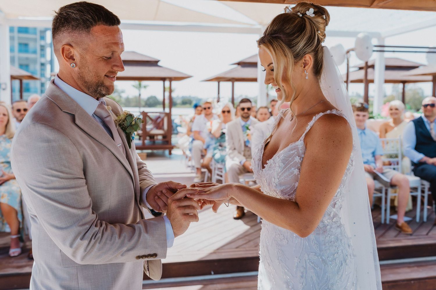 A couple shares a romantic moment during their beach wedding celebration at a seaside venue.