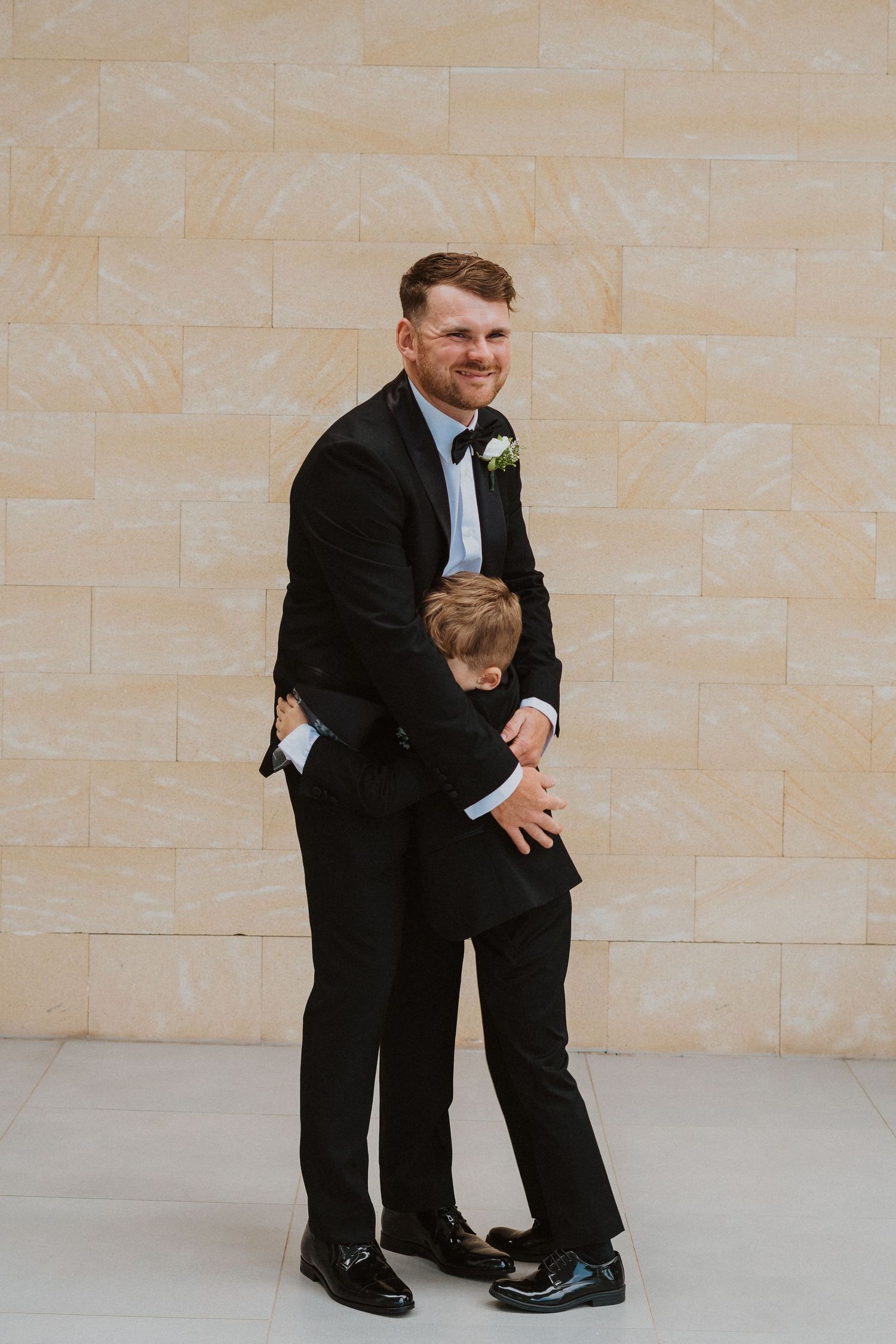 Candid moment of playful interaction between two formally dressed people.