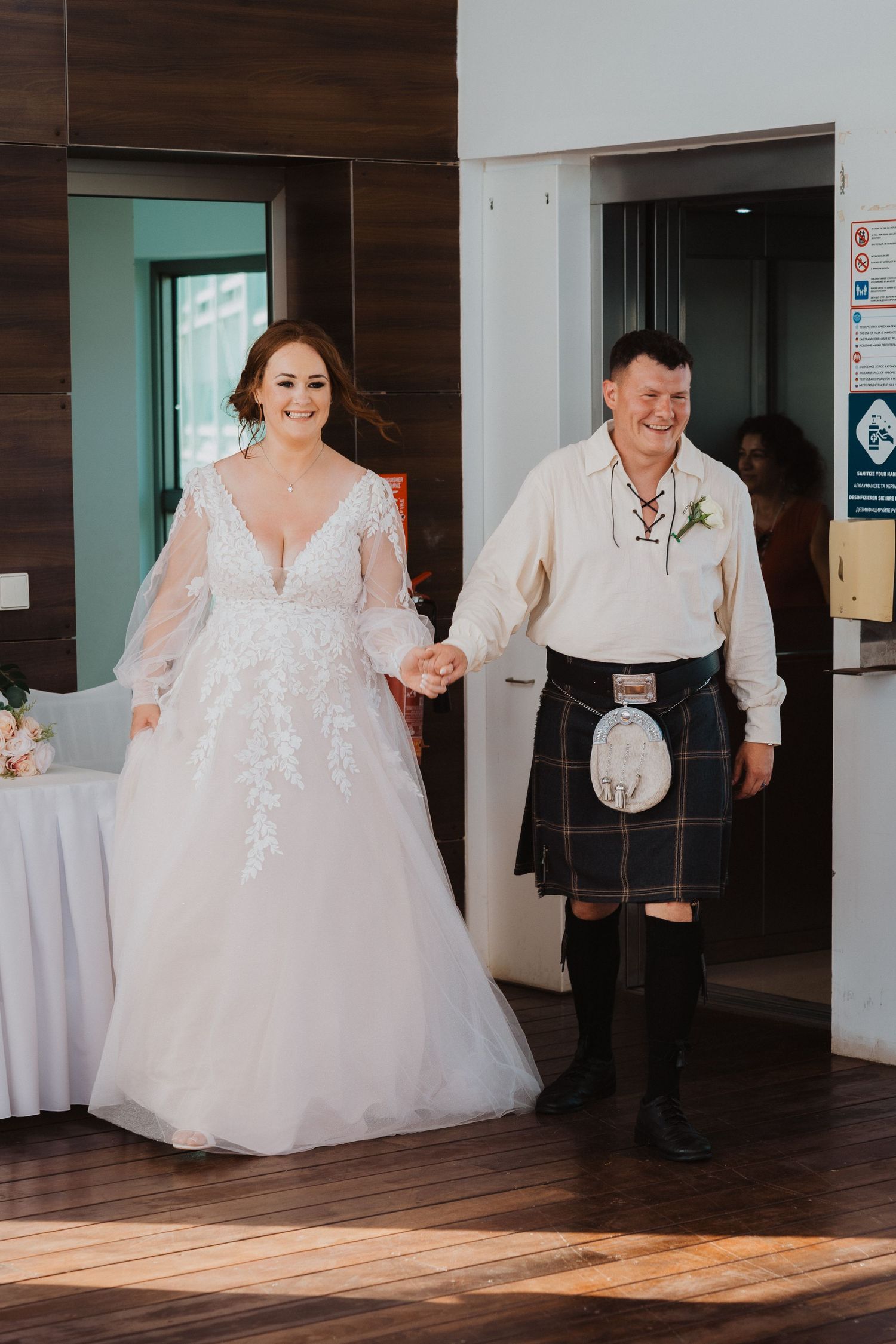 Wedding celebration showing traditional Scottish attire at an indoor venue.