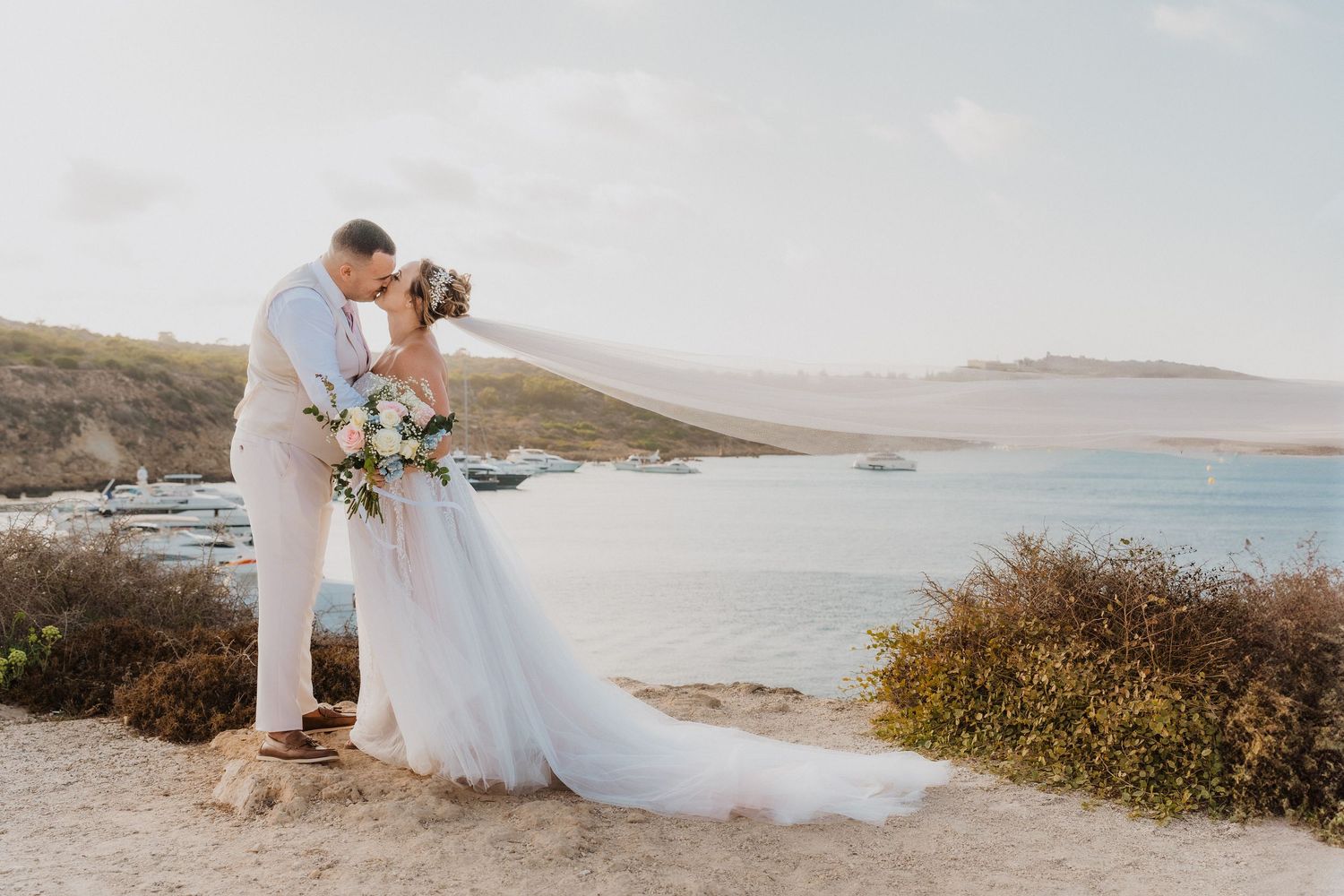 Romantic coastal wedding photography featuring scenic ocean views and natural landscapes at sunset.
