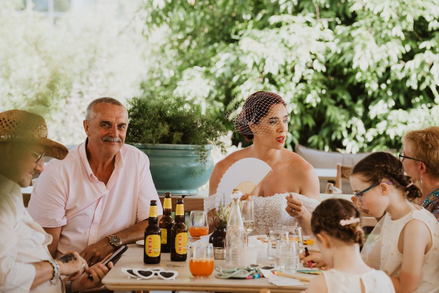 Wedding party enjoys outdoor reception with drinks and conversation.