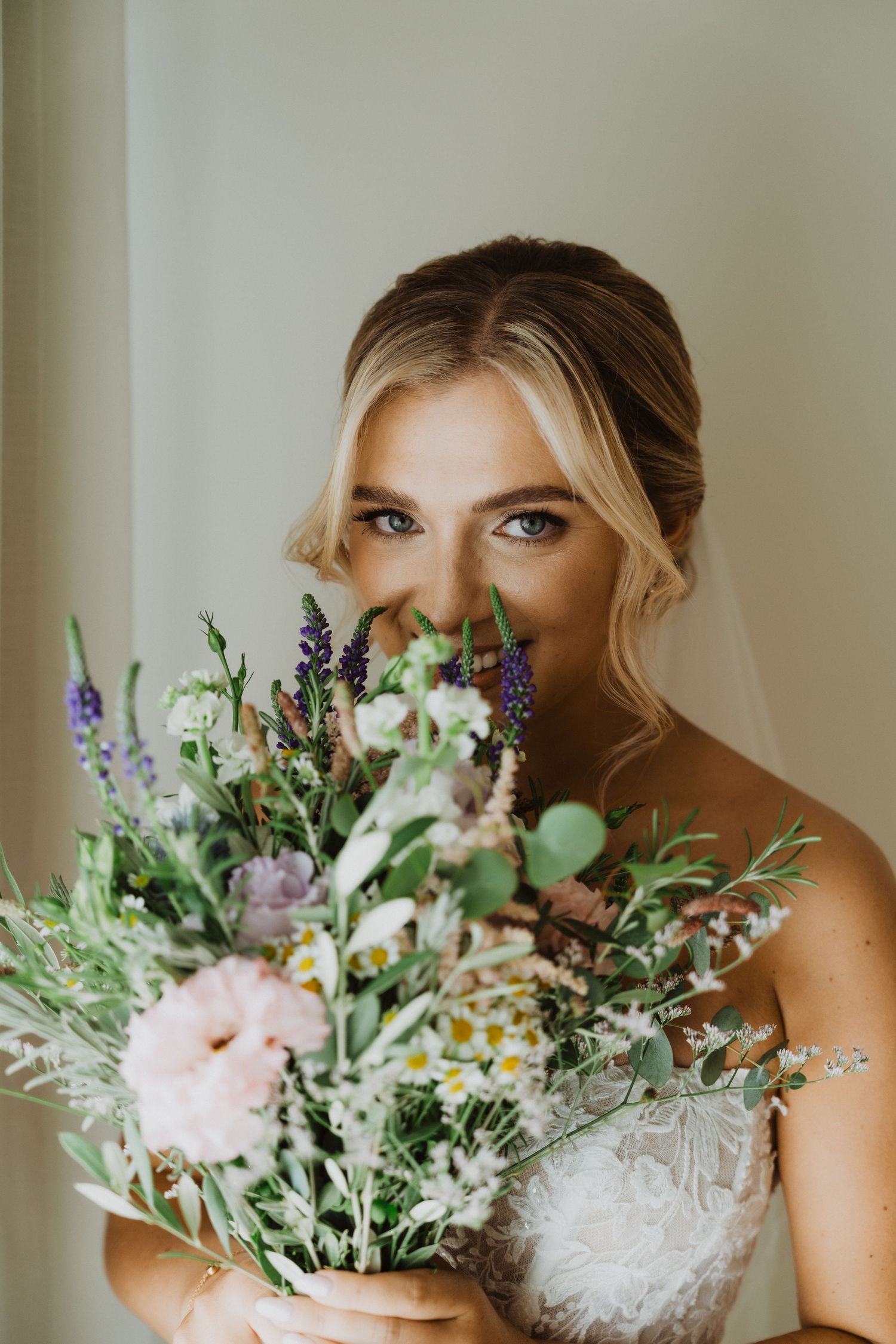 Beautiful wedding bouquet with wildflowers, daisies, and delicate greenery in soft pastel colors.