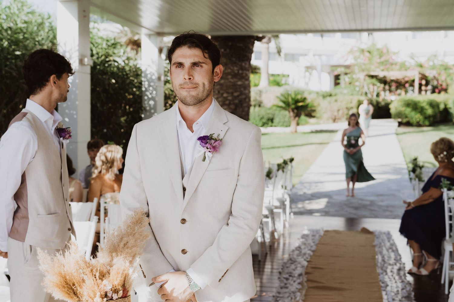 Outdoor wedding venue with white columns and tropical garden setting.
