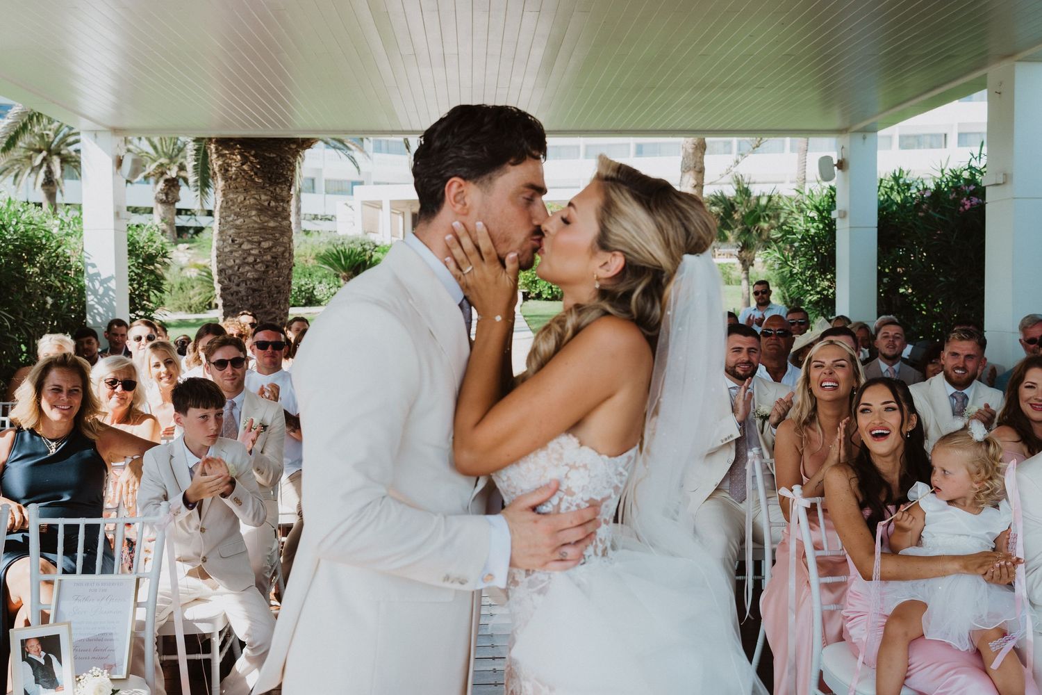 A romantic wedding celebration sequence showing tender moments between newlyweds and guests at an outdoor venue.