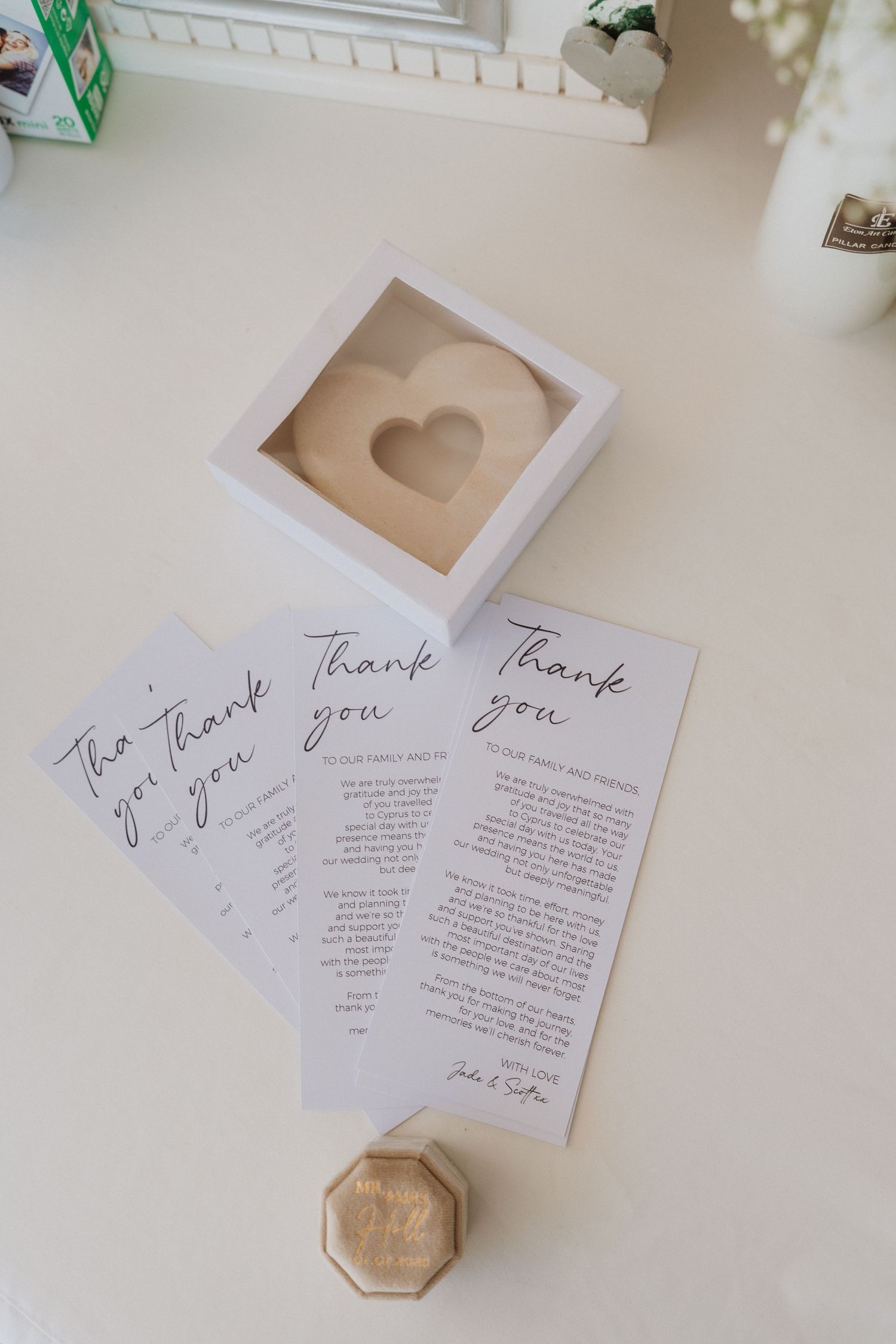 Thank you cards and a white box with heart cutout displayed on light surface with small hexagonal decor piece.