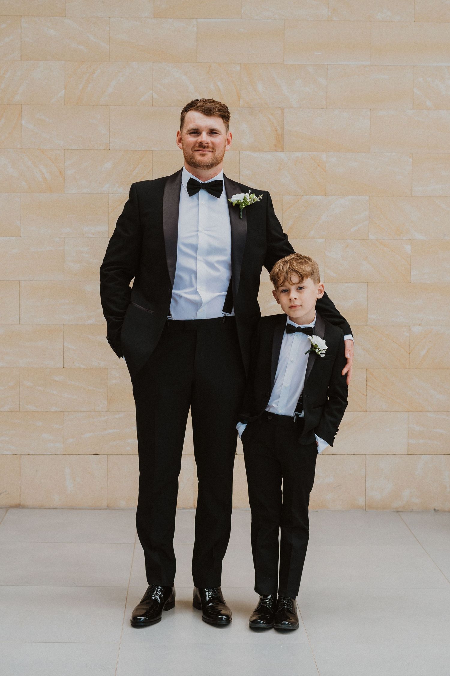 Matching formal tuxedos worn by two people in coordinated black and white attire.