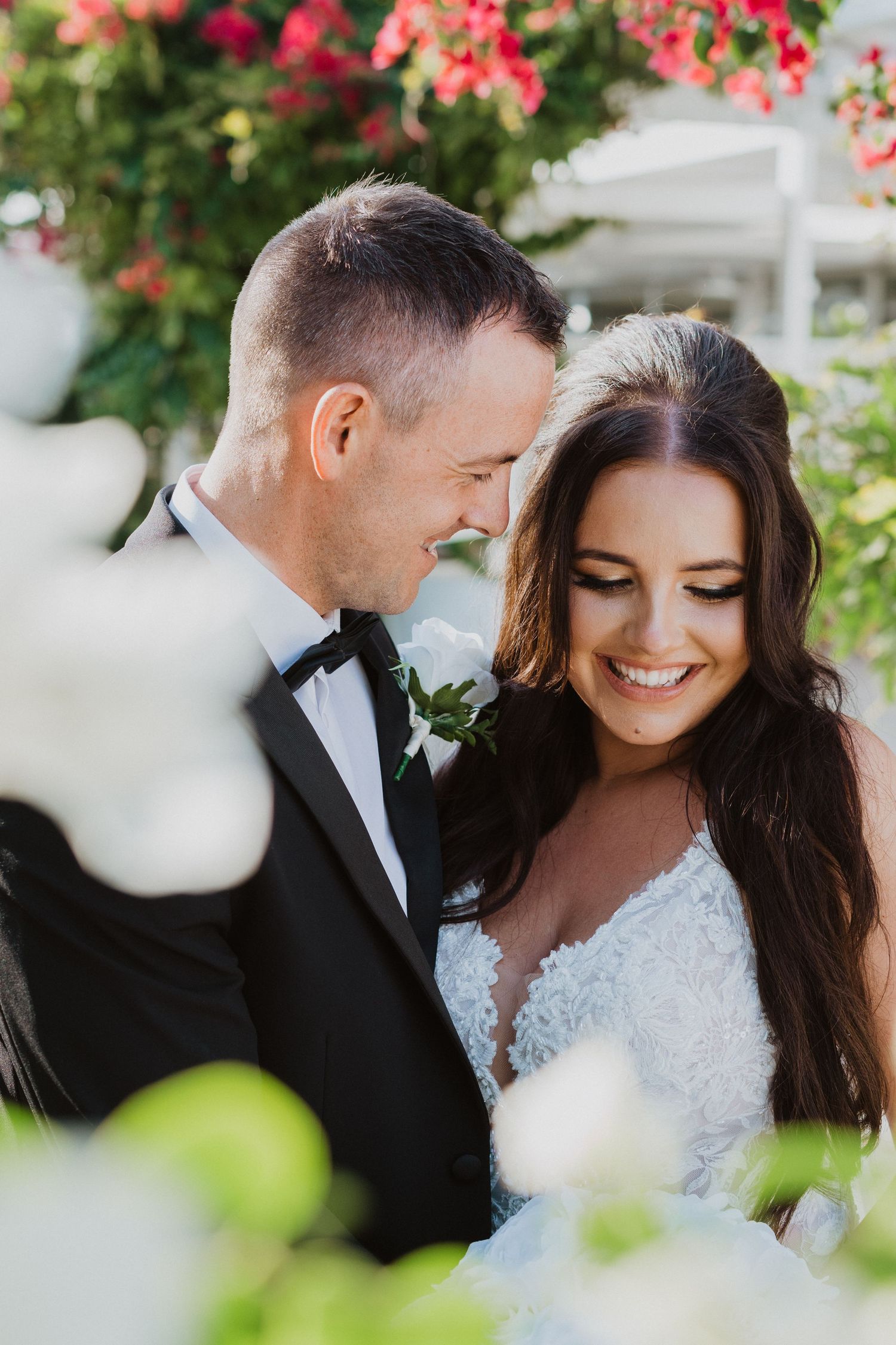 Couple shares intimate moments among blooming bougainvillea during their wedding.