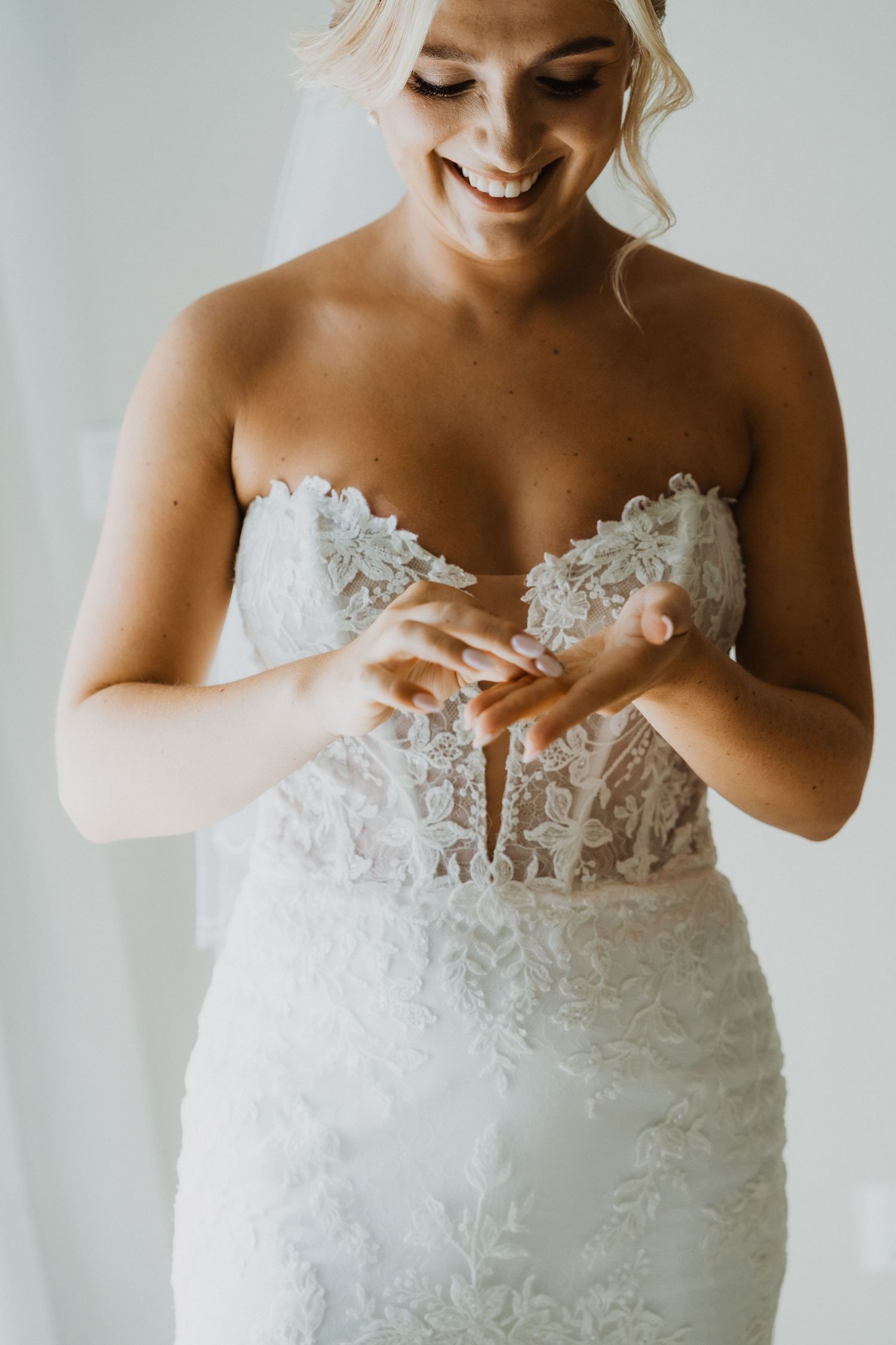 Wedding dress detail showing intricate lace appliques and sweetheart neckline.