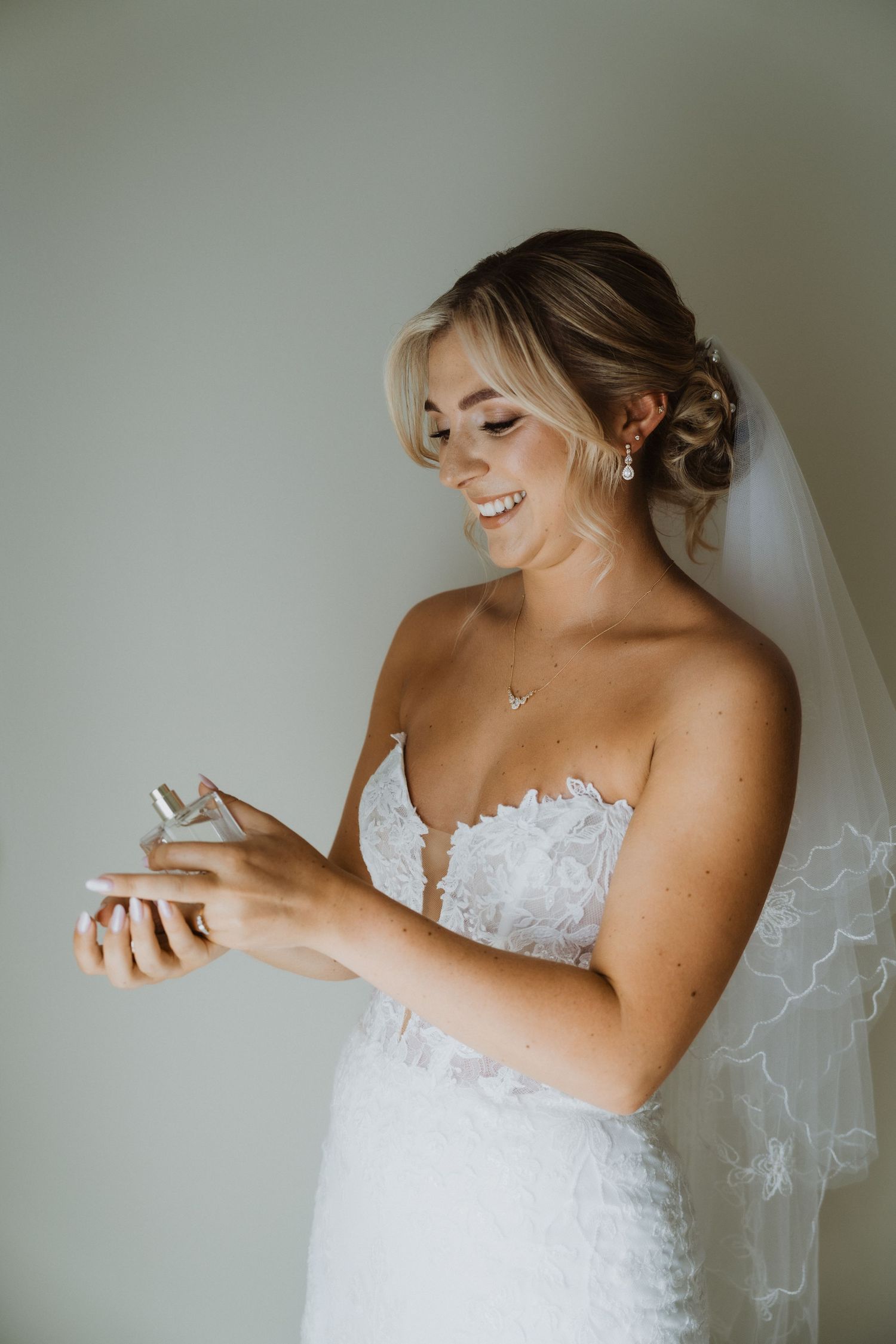 Candid moments of a bride in white lace dress preparing for her wedding day.