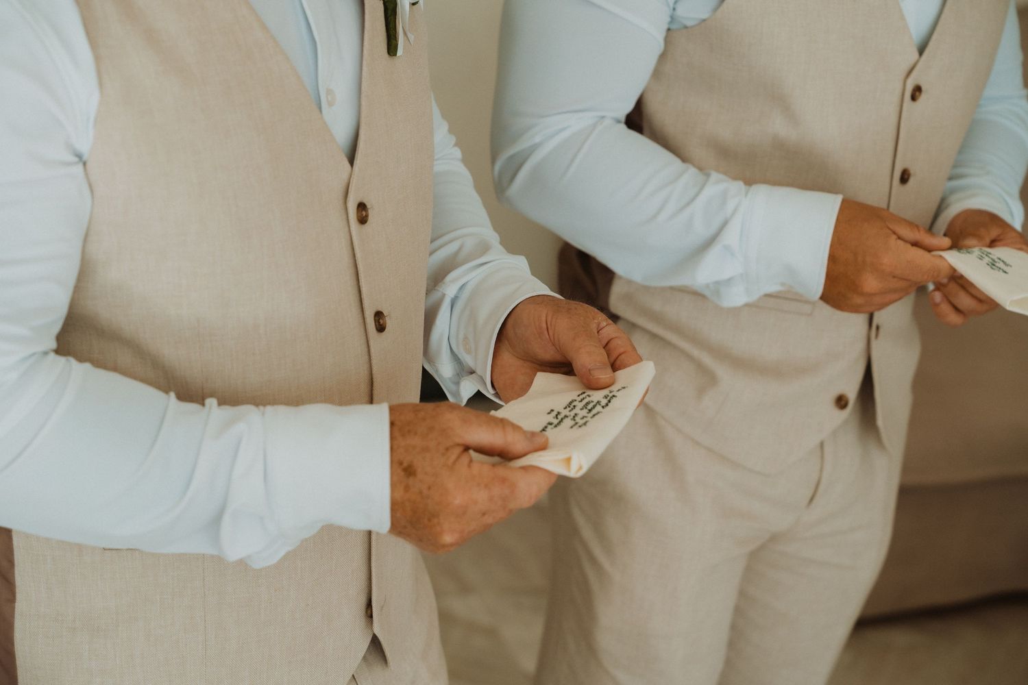 Wedding party members in beige attire gather in a modern indoor setting.