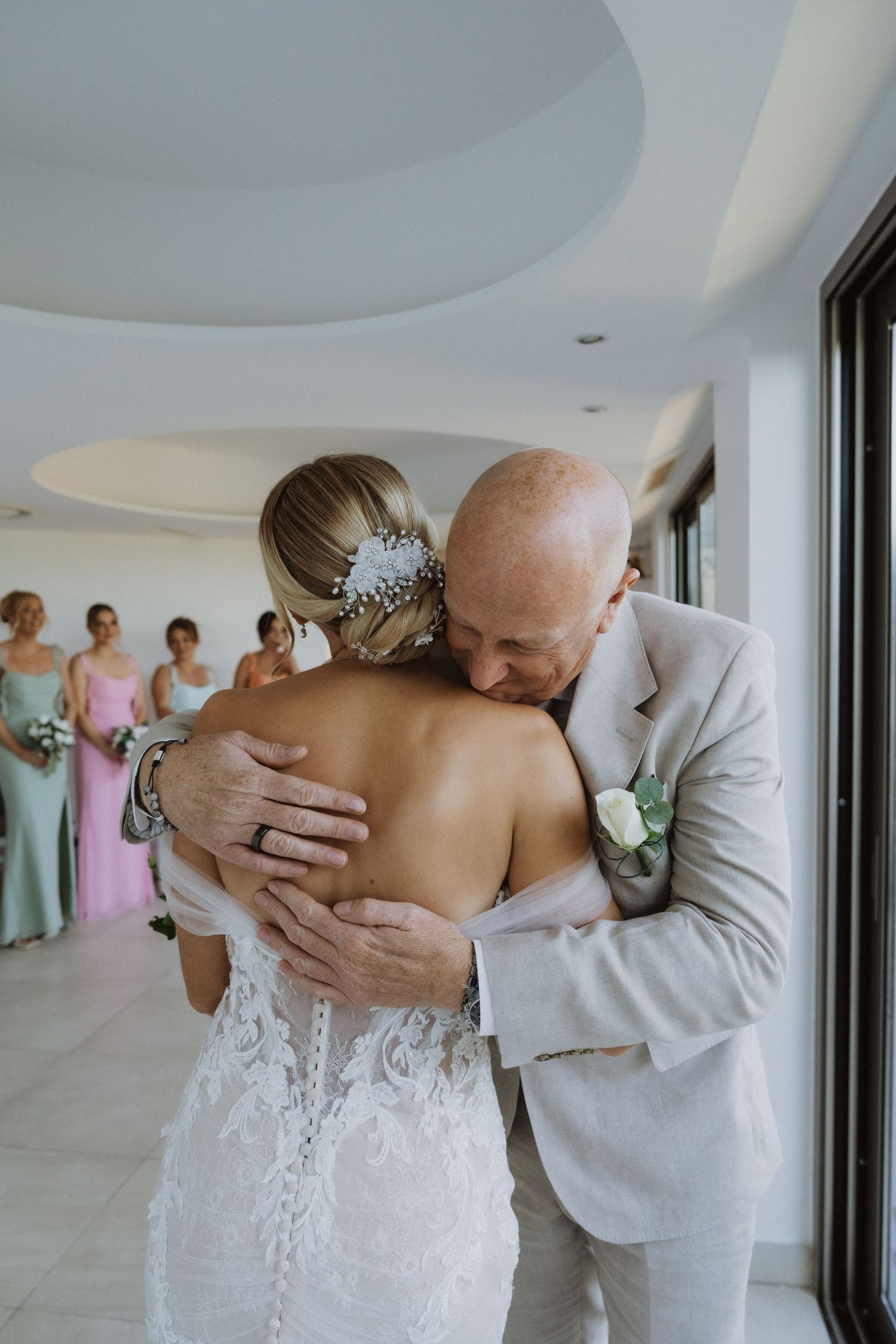 An emotional wedding moment captured in a bright modern space with floor-to-ceiling windows.
