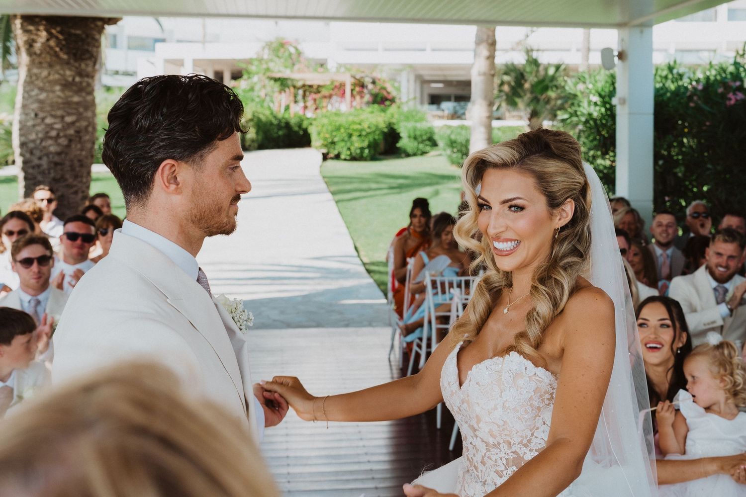 Couple shares a joyful moment during their wedding ceremony while guests look on from their seats.