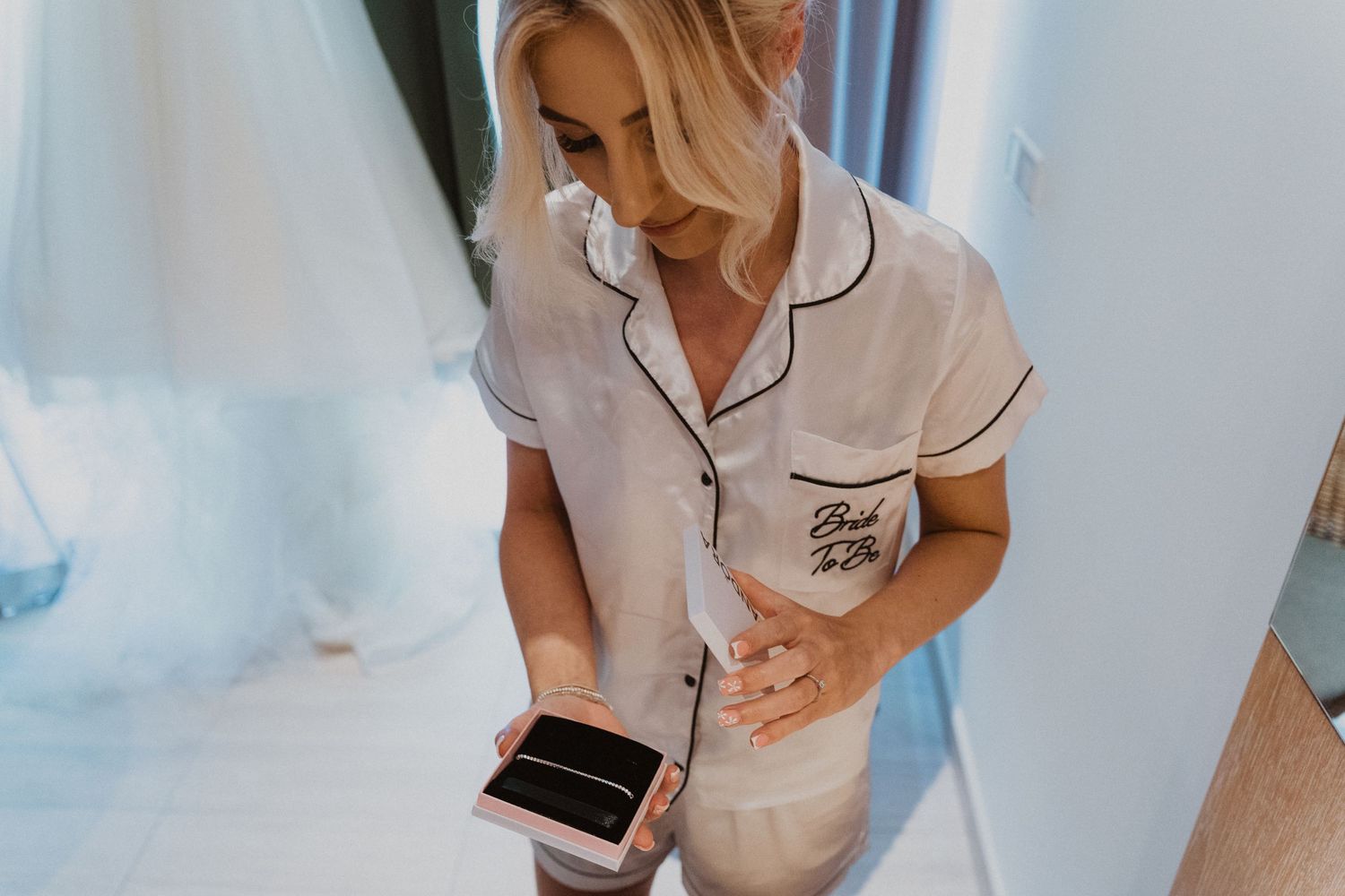 Someone in light pajamas checking their phone during wedding preparations.