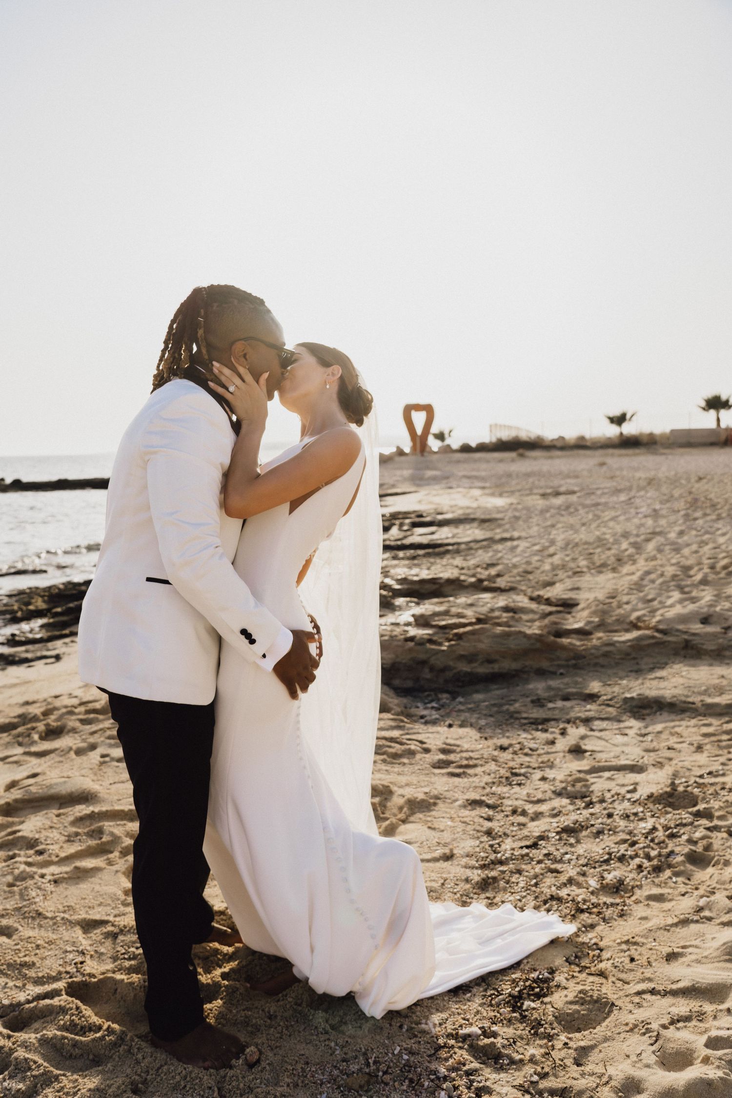 Romantic moment between wedding couple on beach at sunset.