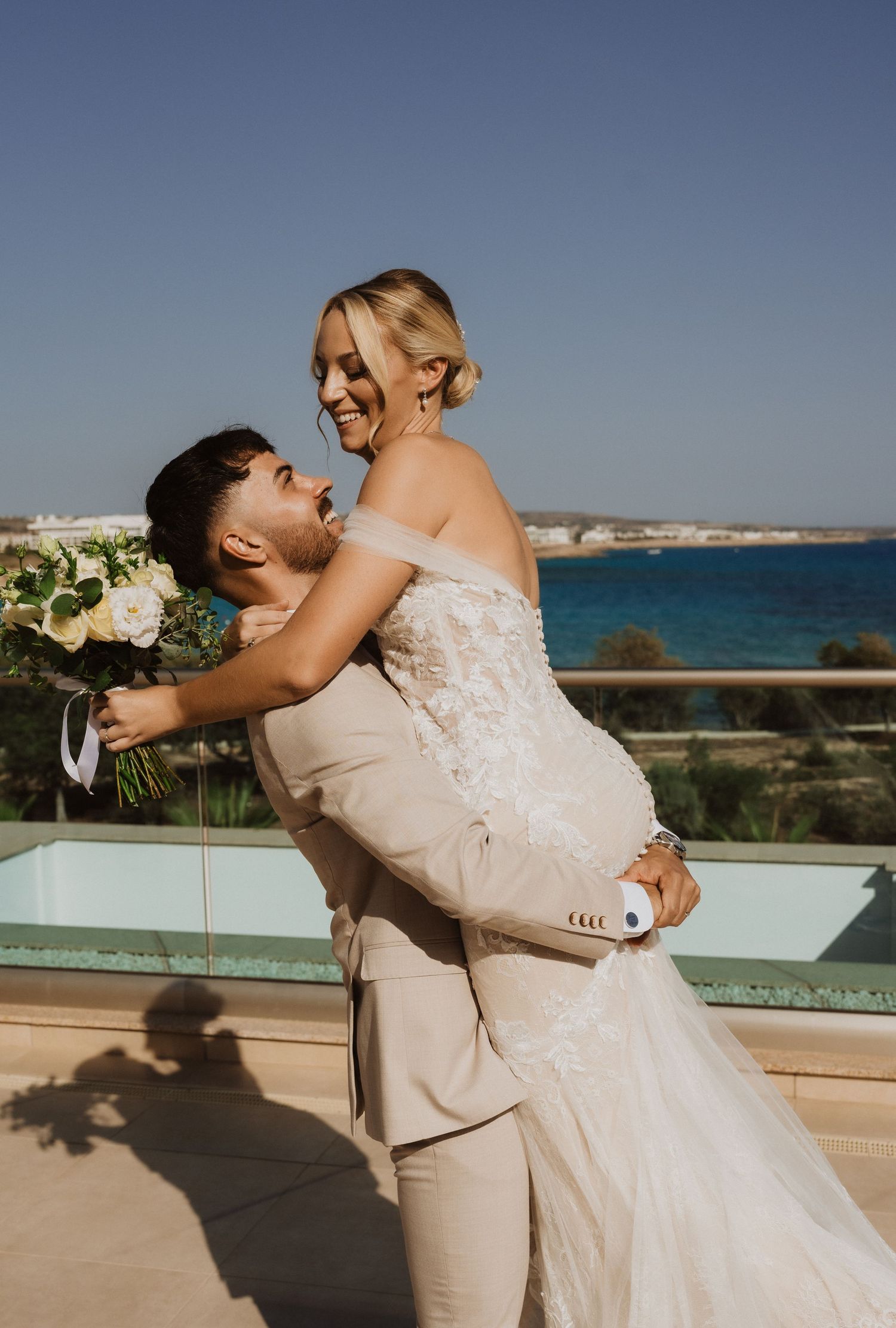 Romantic dance pose on a sunny terrace overlooking the blue Mediterranean waters.