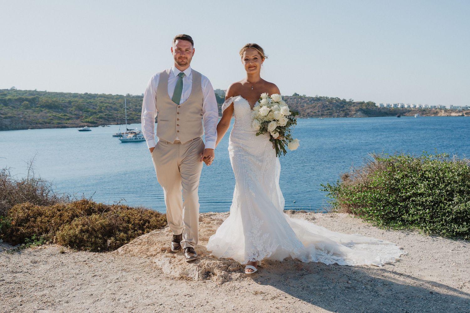 Scenic coastal wedding photo series showing couples in white attire posing against beautiful ocean and beach backdrops.