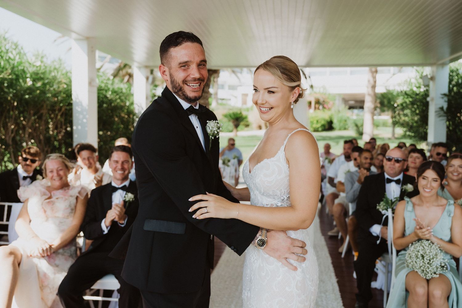 A joyful couple shares their first moments as newlyweds during an outdoor wedding ceremony.