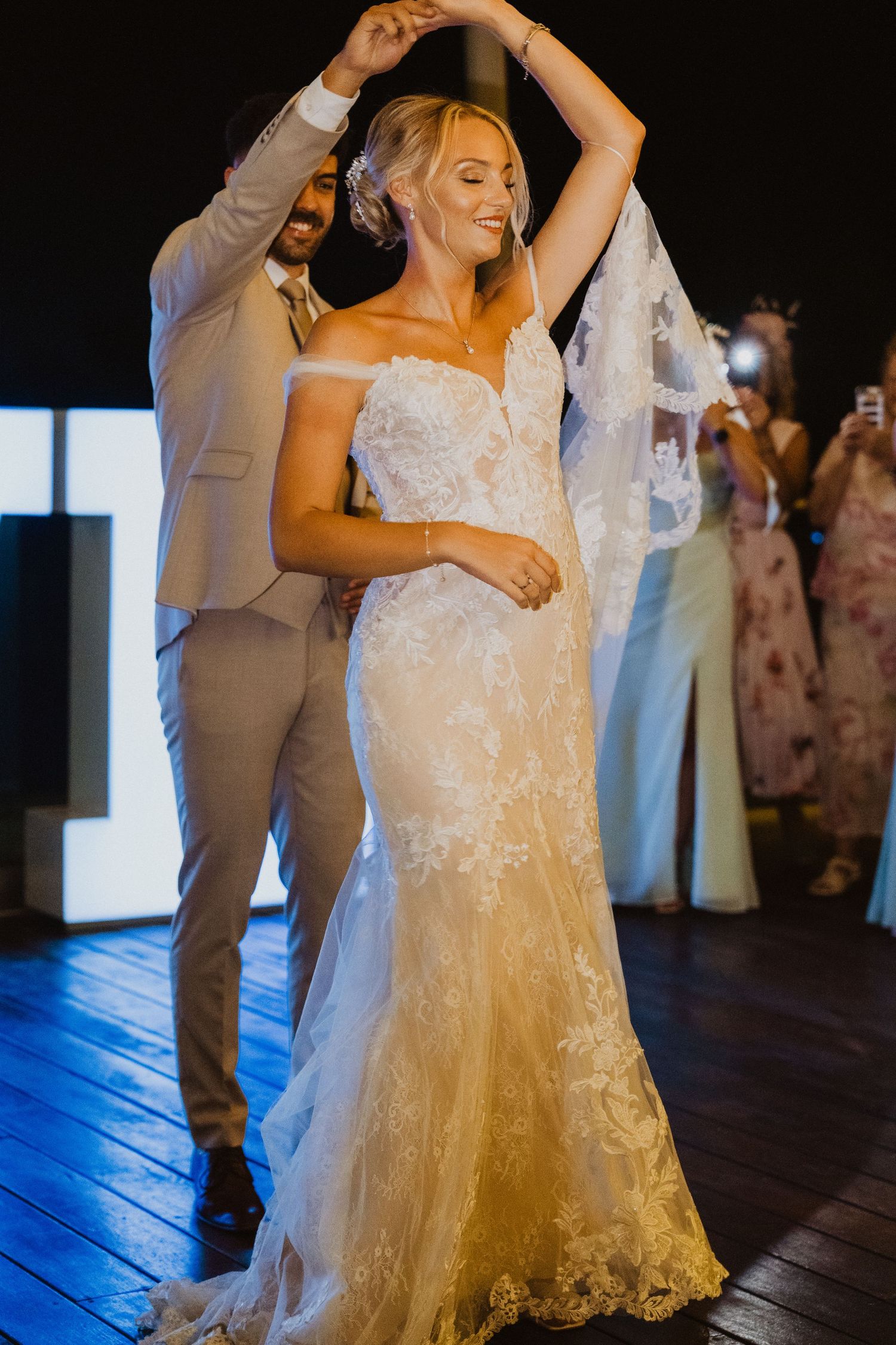 Couple dancing at wedding reception with bride wearing lace mermaid gown.