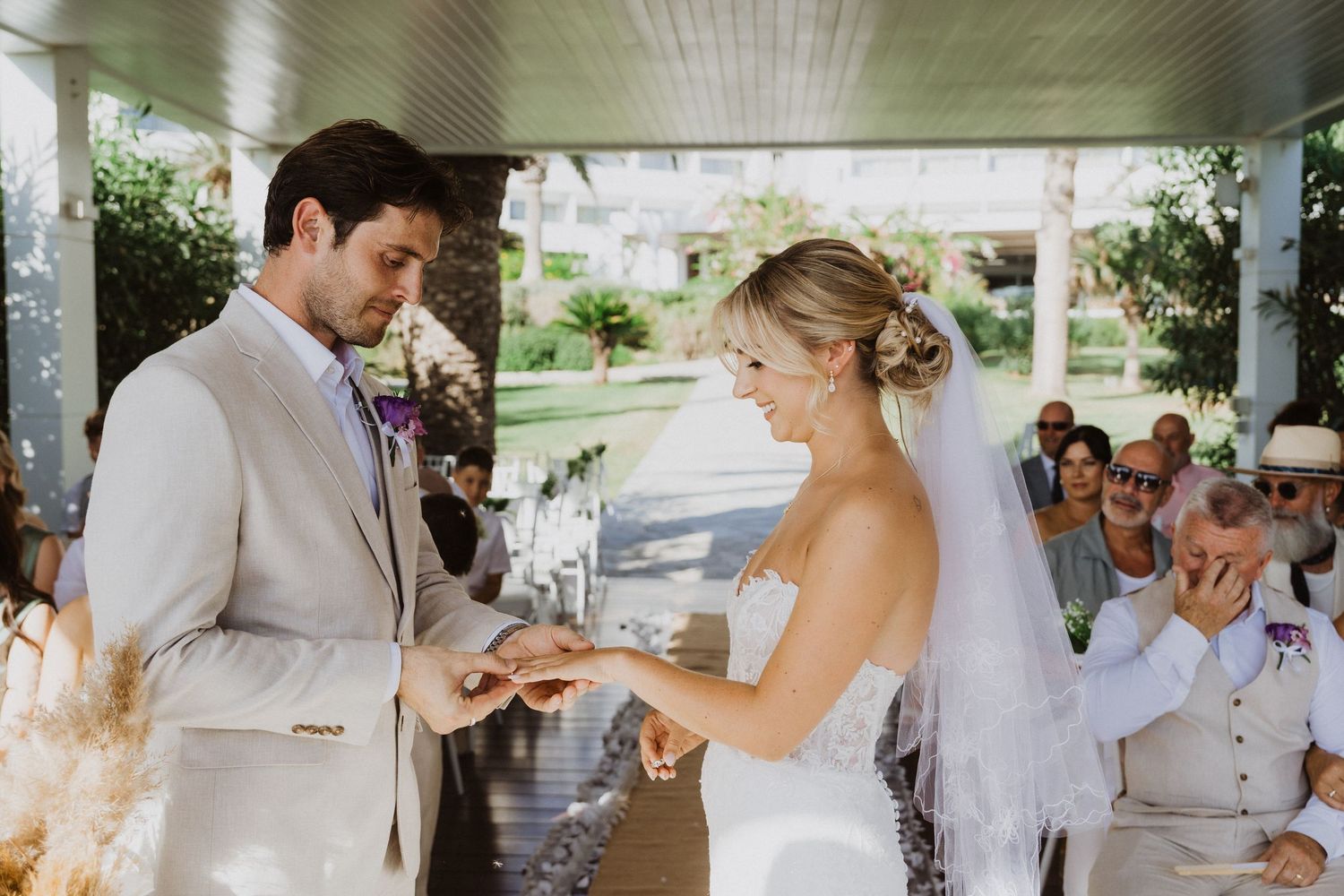 Candid moments of a wedding celebration captured under an outdoor pavilion with white columns.