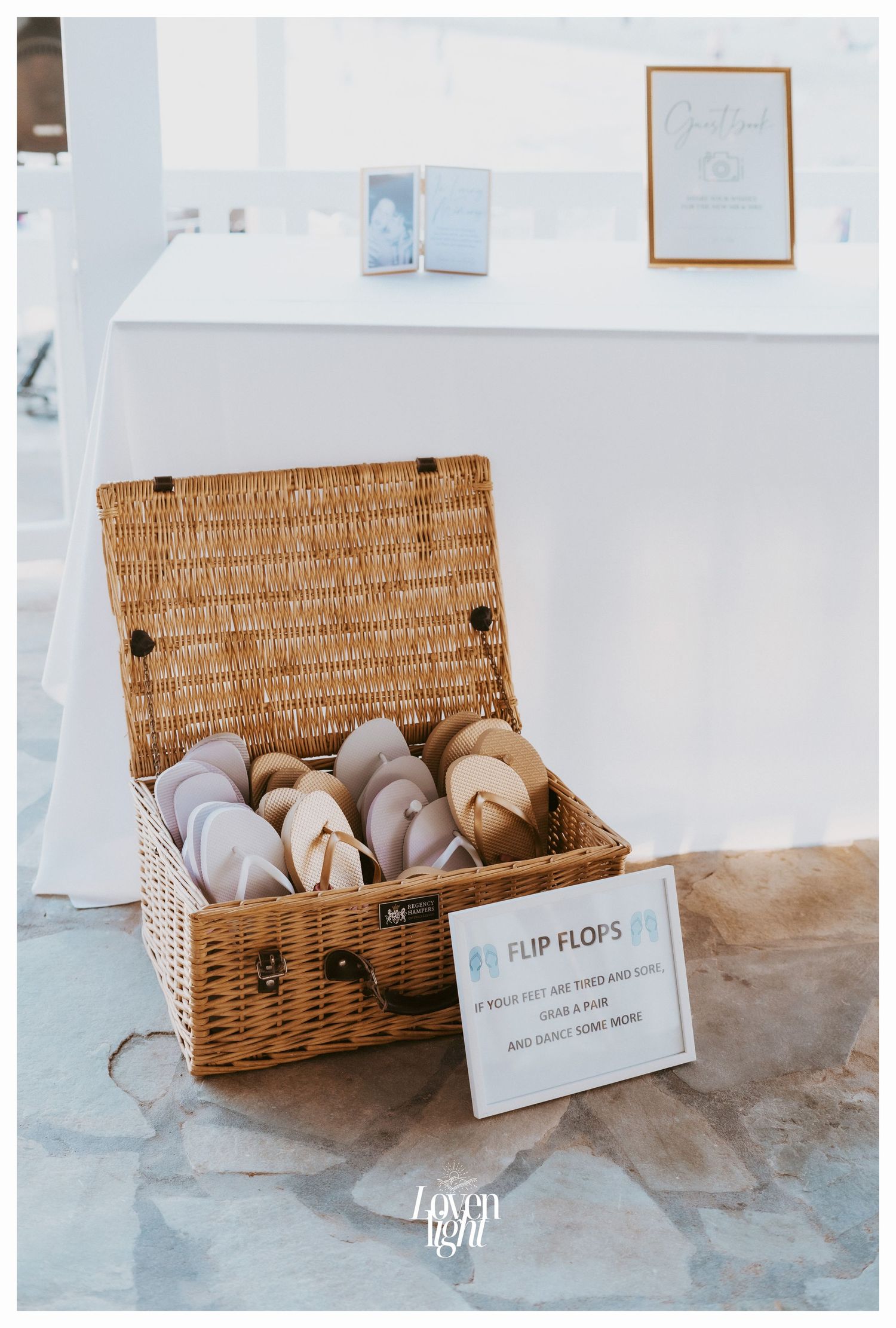 Wicker basket filled with flip flops for wedding guests displayed with instructional sign.