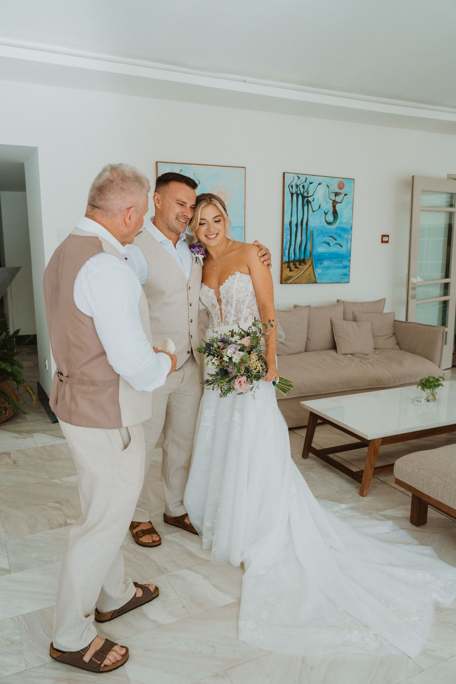 Wedding party poses in an elegant indoor setting with white and beige decor.