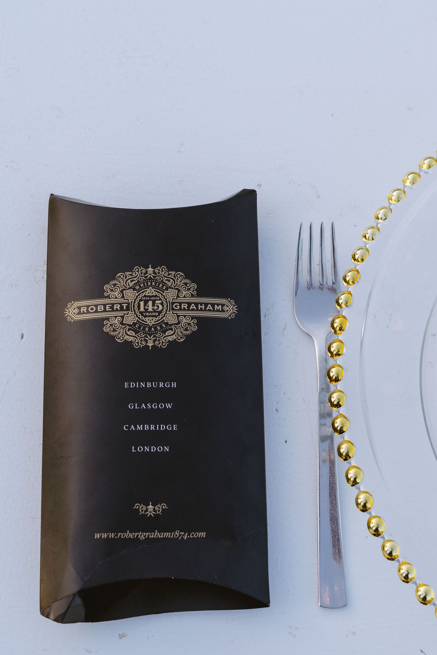 Elegant menu card and gold-beaded charger plate setting at formal event.
