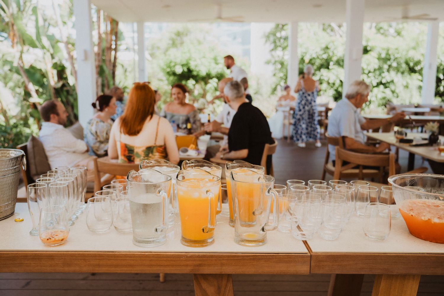 Outdoor dining area with refreshing orange drinks set on a wooden table.