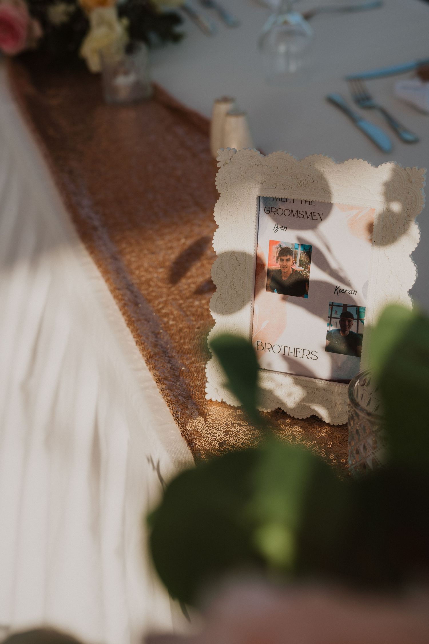 Decorative vintage-style frame with photos on a rose gold sequined table runner.