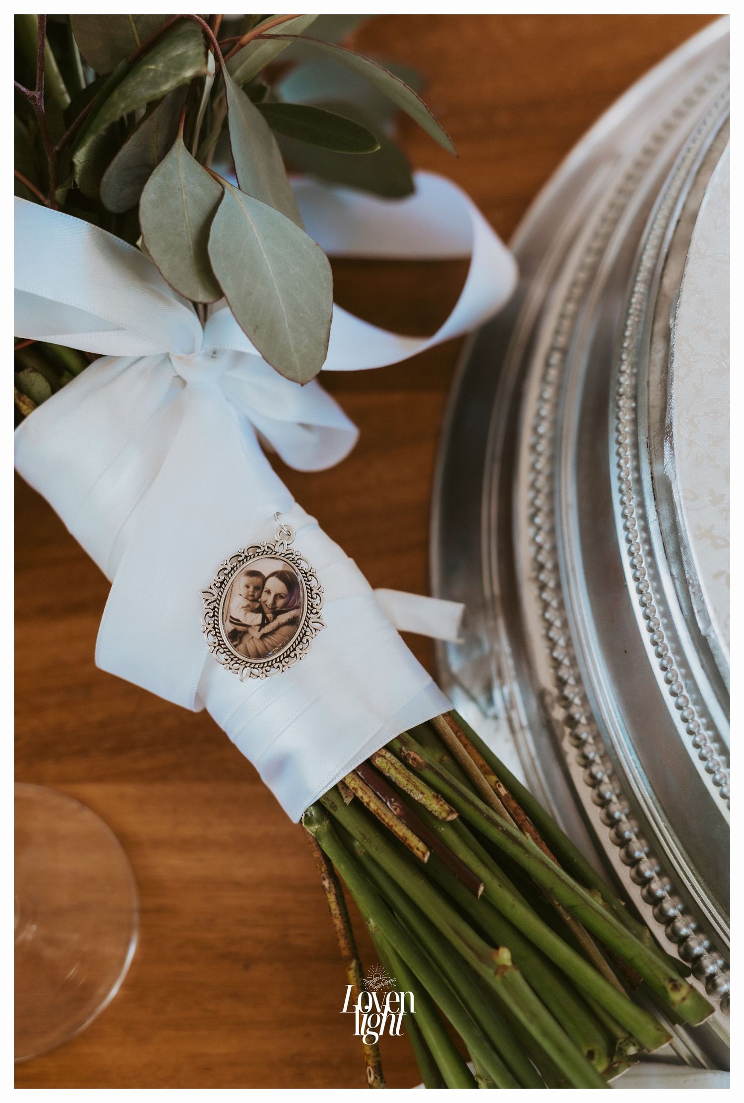 Detailed shot of bridal bouquet wrap with vintage-style brooch decoration.