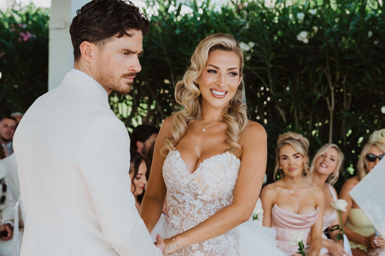 A wedding celebration outdoors with people dancing and enjoying festivities in a garden setting.