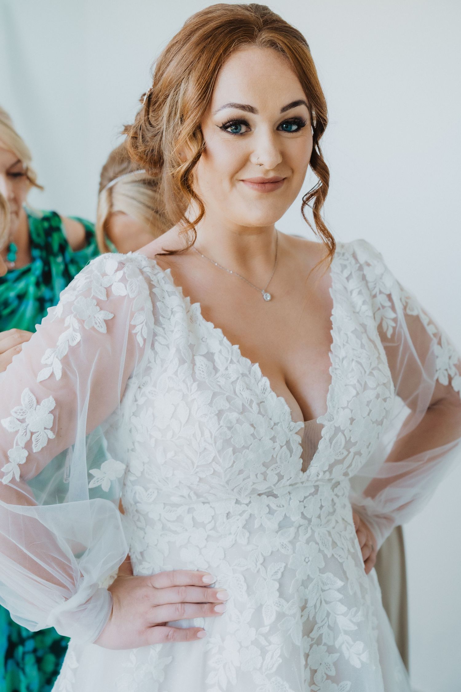Elegant lace wedding dress with sheer sleeves and delicate floral details.
