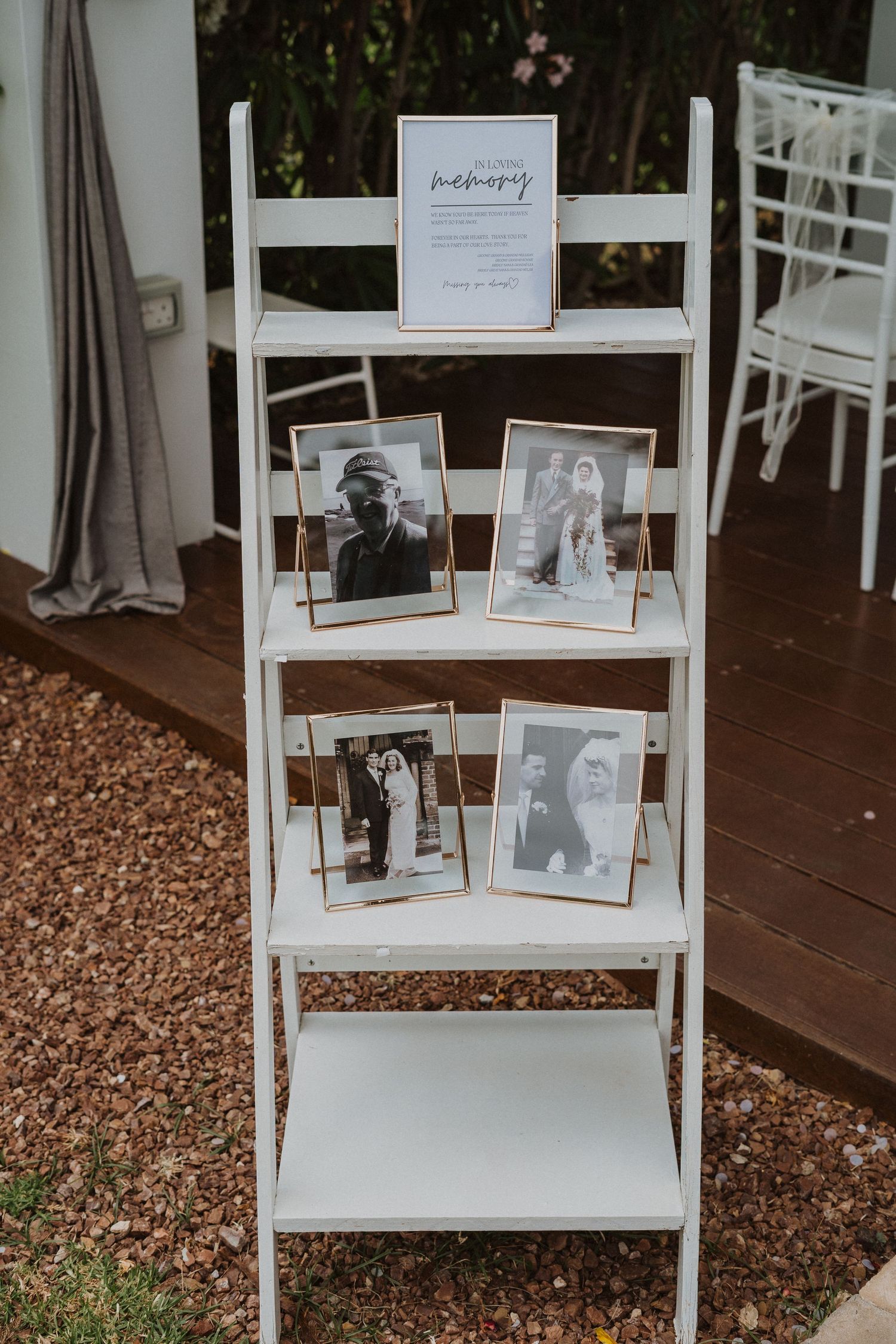 White ladder shelf displaying vintage photos at wedding reception.