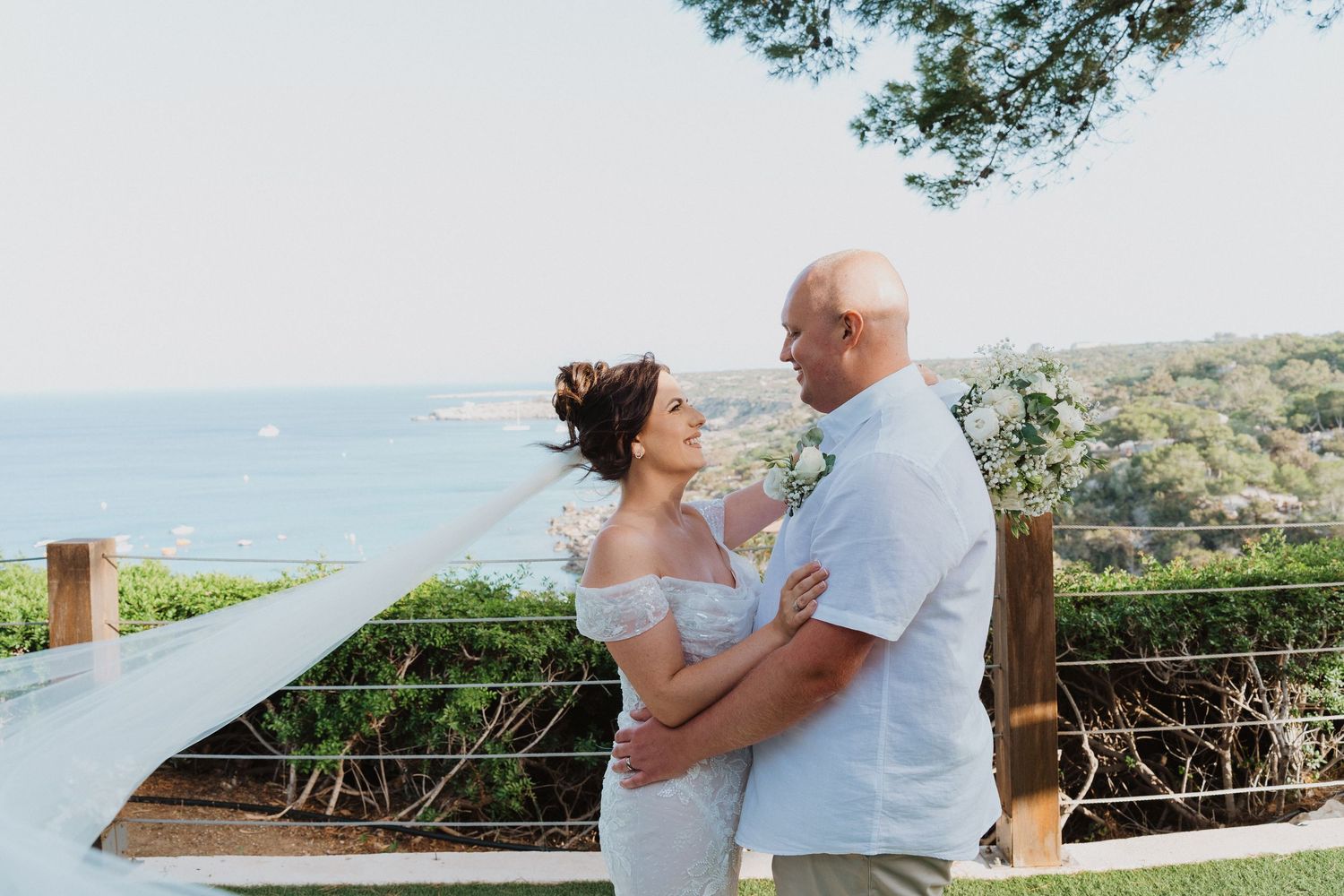 Couple sharing romantic moments on an outdoor terrace overlooking scenic mountain landscapes at sunset.