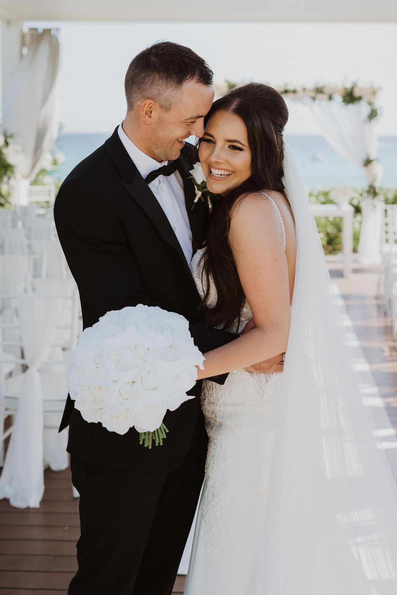 Intimate moment between newlyweds at waterfront wedding venue.