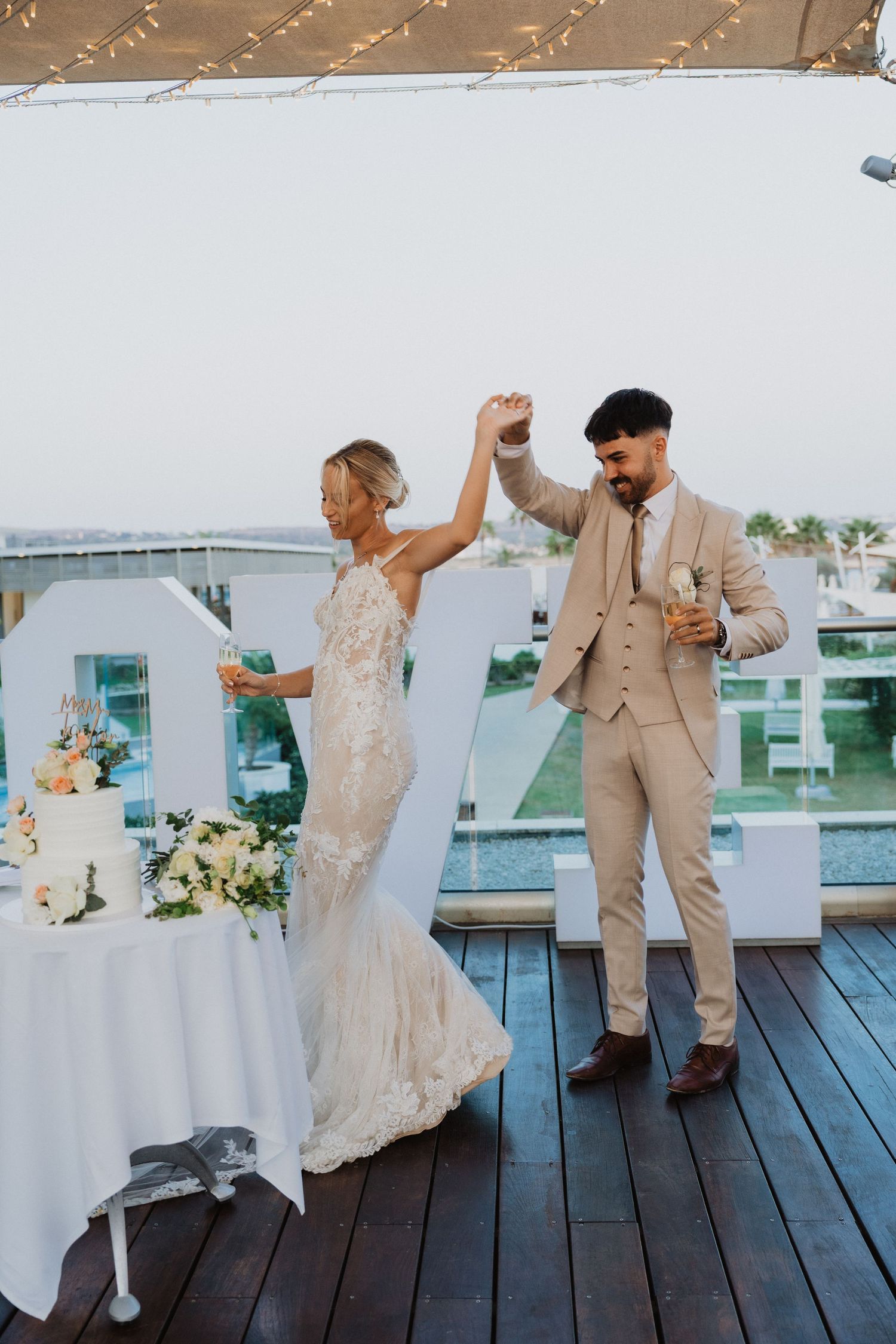 Wedding couple dancing and celebrating near their cake.