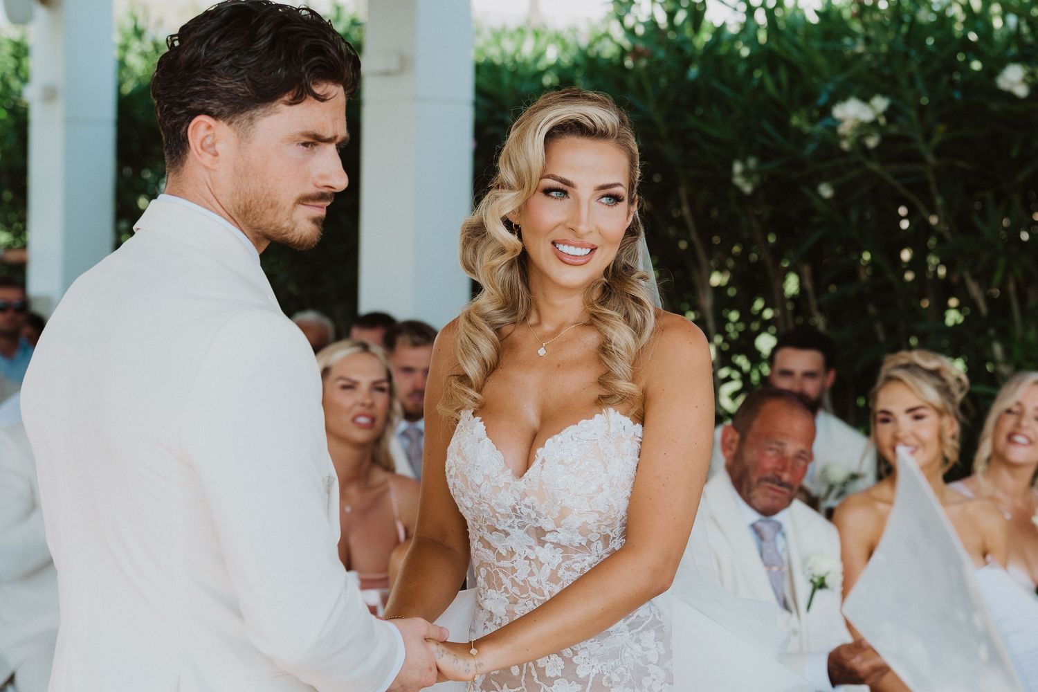 A wedding couple shares a joyful dance together while guests watch and celebrate at an outdoor reception.