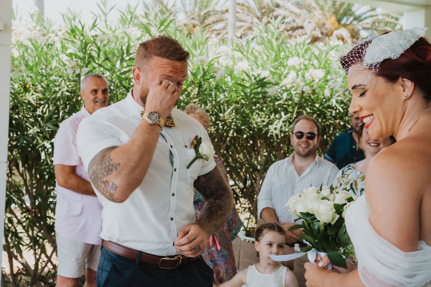 An emotional moment captured during an outdoor wedding ceremony under a covered porch.