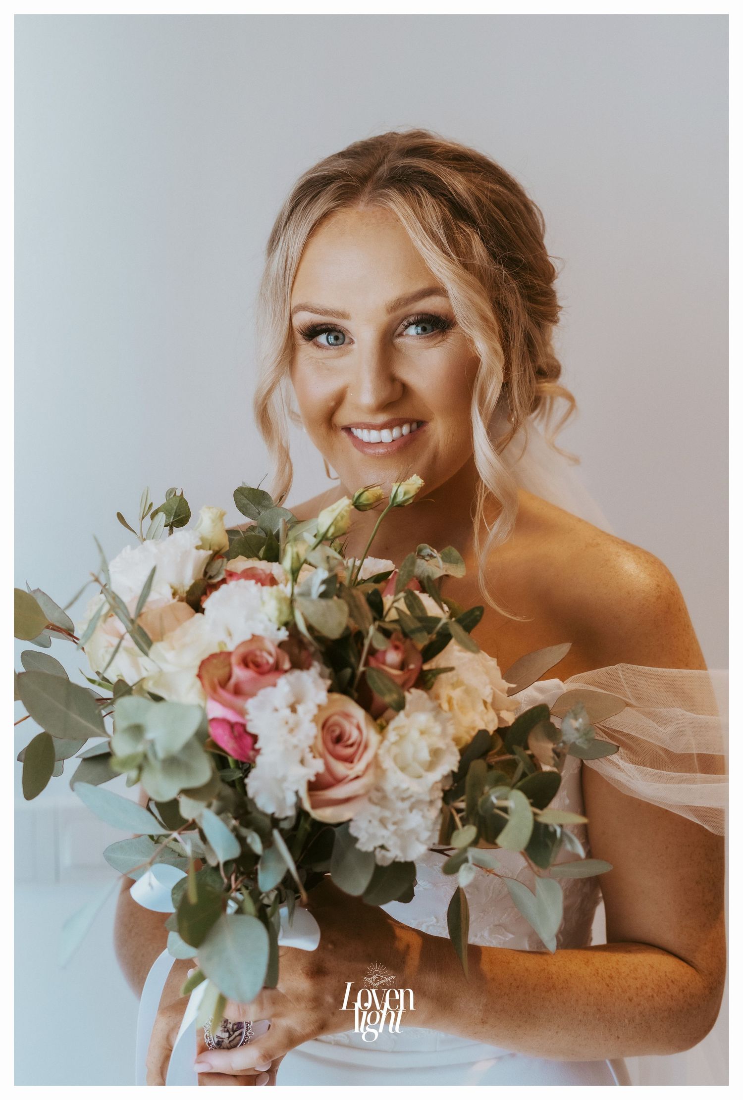 A bridal portrait featuring an elegant bouquet with blush roses, white flowers and eucalyptus greenery.