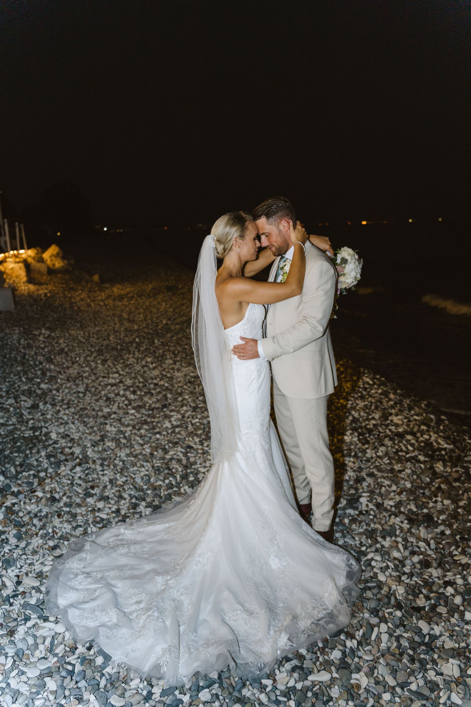 Elegant wedding photo at night showing off intricate lace details of bridal gown.