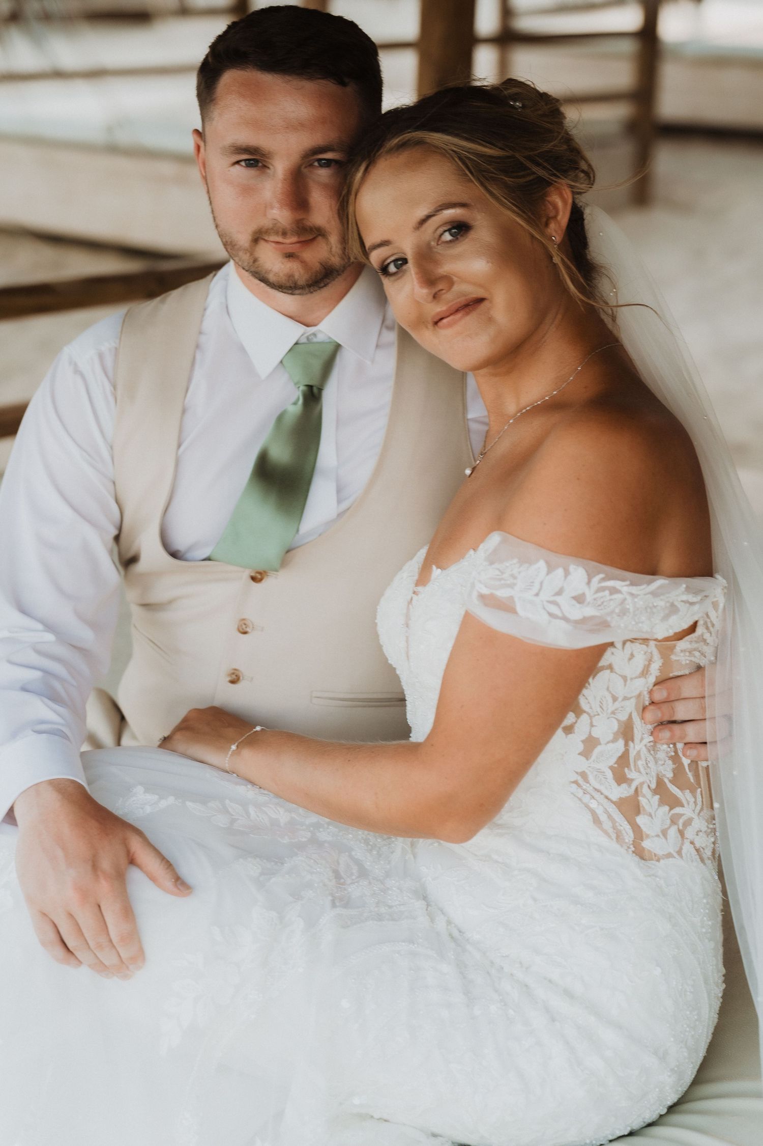 A couple in wedding attire share intimate moments while sitting together in a series of romantic poses.