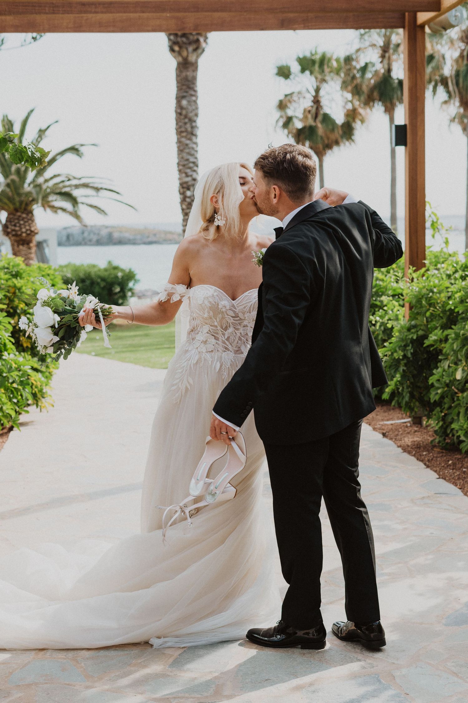 Wedding couple dancing together on an elegant covered terrace with tropical landscaping.