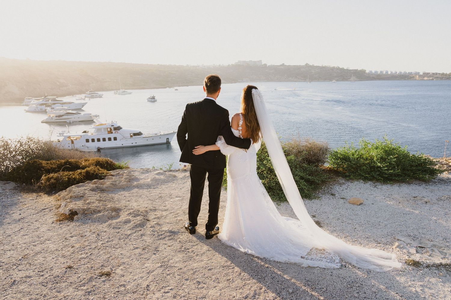 A coastal wedding photoshoot with dramatic ocean views and rocky shoreline.