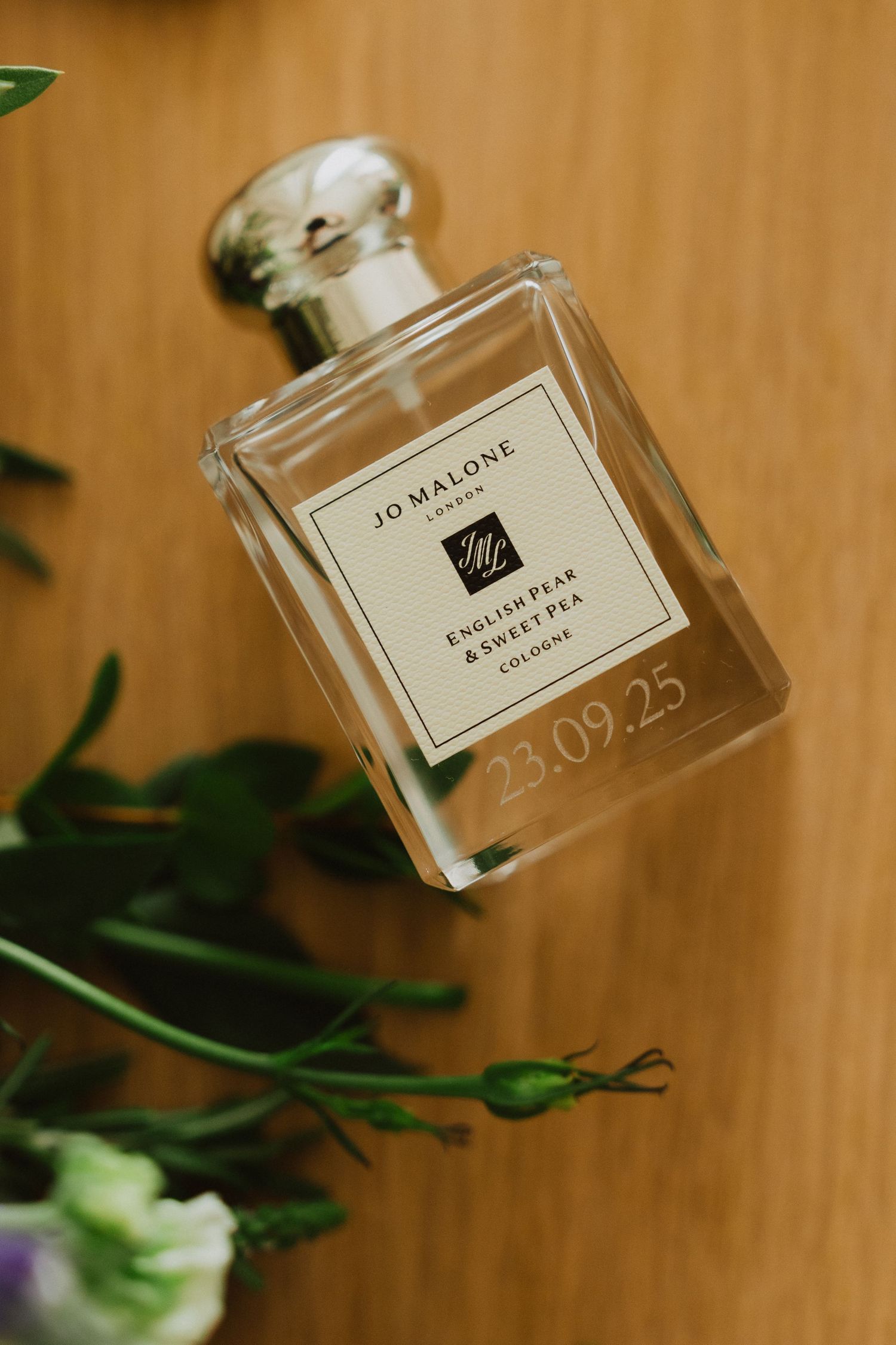 Jo Malone perfume bottle displayed on wooden surface with soft lighting.