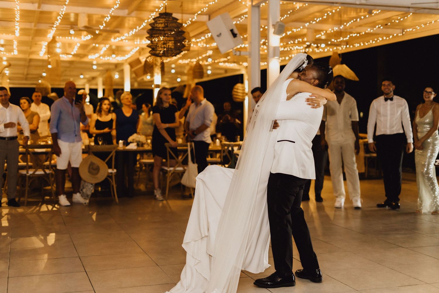Couple dancing at their wedding reception in an elegantly lit indoor venue.