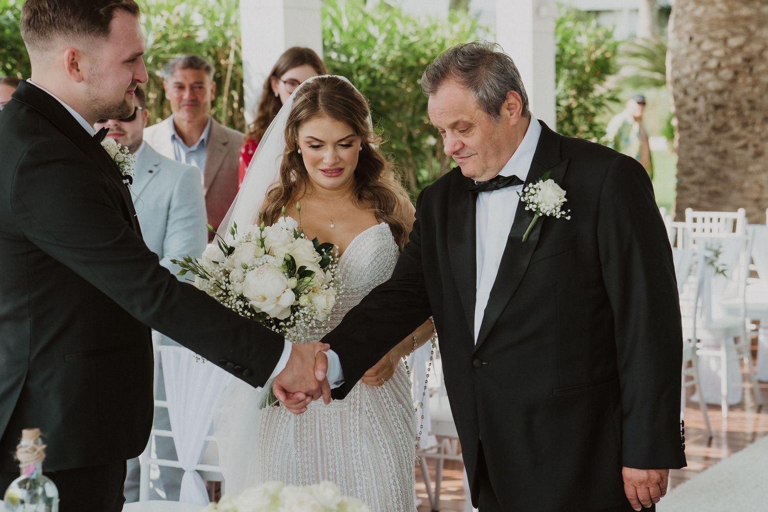 Groom shaking hands with father of the bride during the wedding ceremony handoff.