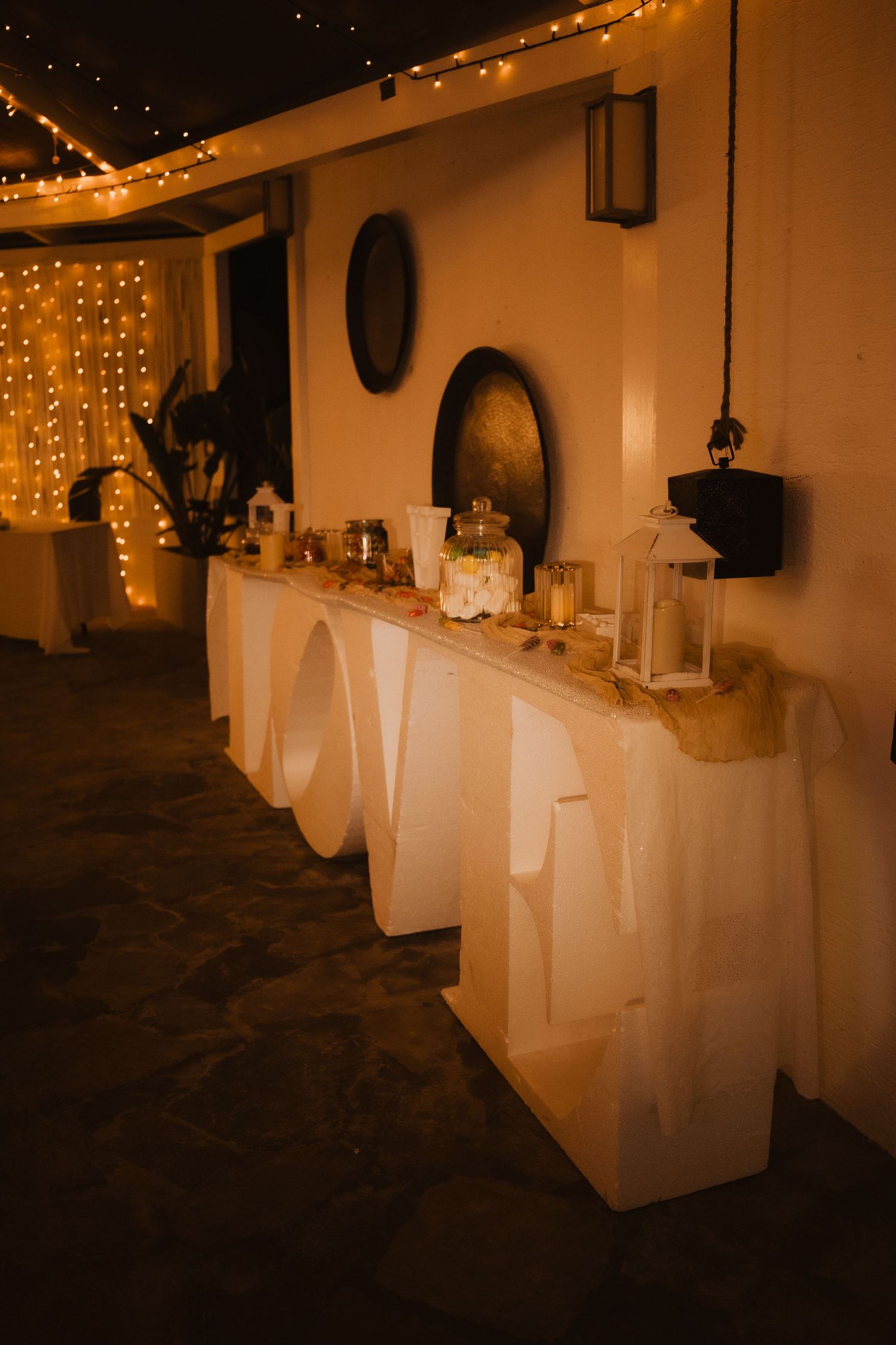 Elegant wedding reception table setup with string lights and decorative elements creating a warm ambiance.
