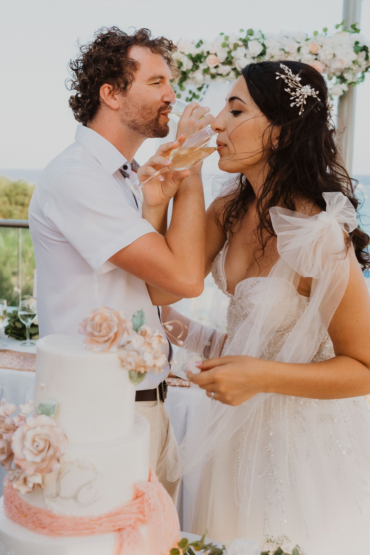 A couple shares an intimate moment while drinking champagne at their wedding reception.