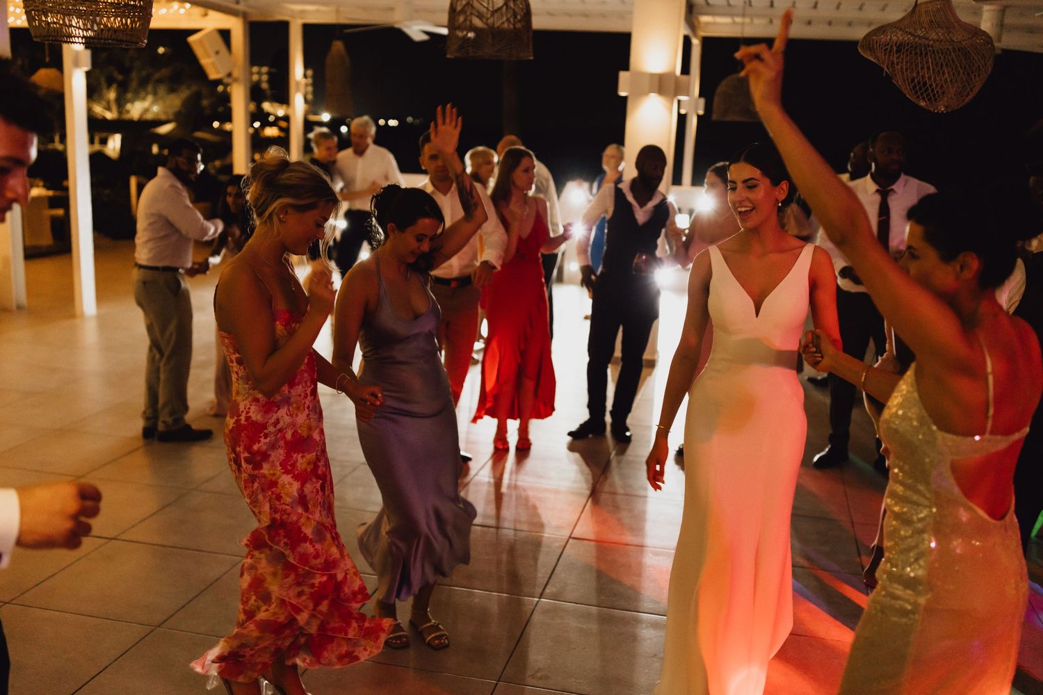 Party guests dancing and having fun on a lively dance floor at an evening celebration.