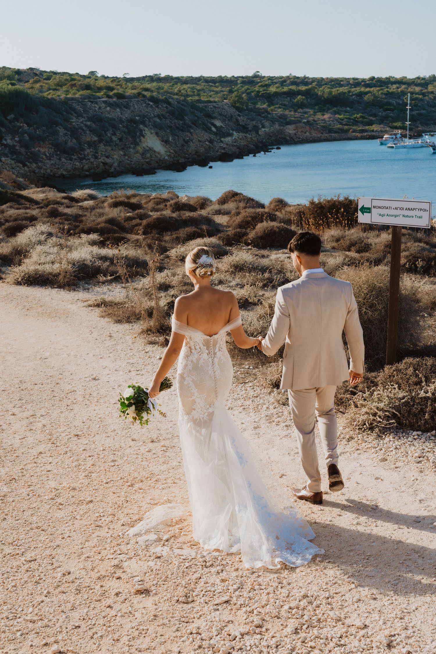 Couple walking hand in hand along a scenic coastal path in Cyprus.